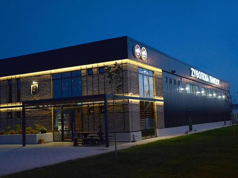 Front view of illuminated Pineios Brewery building by night